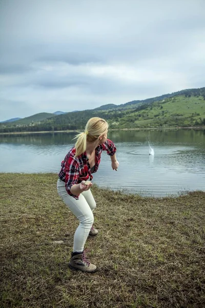 Молода Блондинка Кидає Каміння Воду — стокове фото