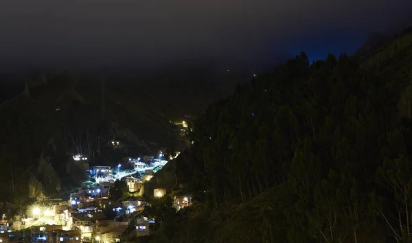 Poziome Ujęcie Oświetlonej Wioski Wzgórzu Obok Lasu Nocy — Zdjęcie stockowe