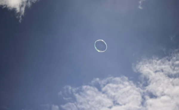 青い空に向かって空に浮かぶ小さなシャボン玉 — ストック写真