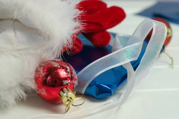 特写照片 白色背景的圣诞礼物 红色圣诞树球和手套 — 图库照片