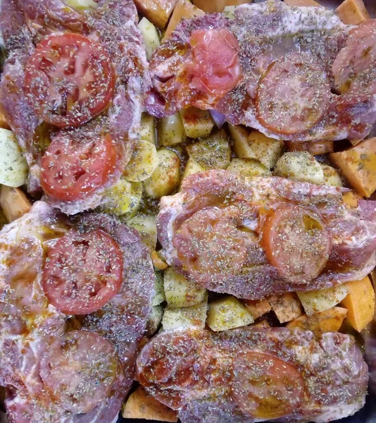 ジャガイモ スカッシュ トマト 調味料でマリネされた調理されていない肉の垂直ショット フードブログに最適 — ストック写真