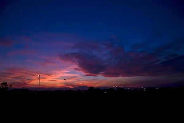 美しい夕日の間に曇った空の下で丘や街灯のシルエット 壁紙に最適です — ストック写真