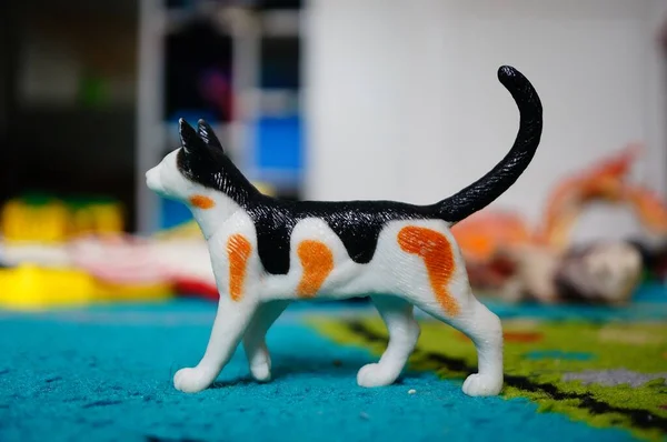 Close Brinquedo Gato Branco Com Manchas Pretas Vermelhas Tapete Azul — Fotografia de Stock