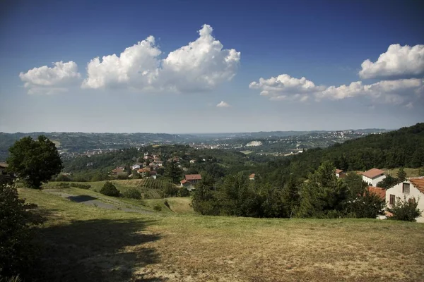 背景には曇り空の緑の丘の上の家の景色 — ストック写真