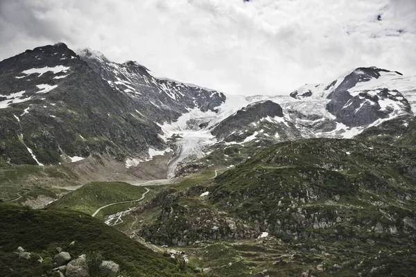 Dar Bir Yol Manzarası Tepesinde Karla Kaplı Yüksek Dağlarla Çevrili — Stok fotoğraf