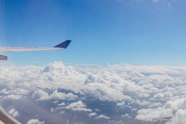 从玻璃窗看到的云层和机翼的景象 — 图库照片