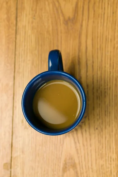 Ein Blauer Becher Mit Kaffee Auf Einem Holztisch — Stockfoto