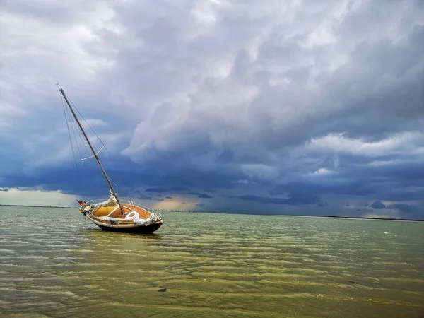 位于德国北部美丽的云天之下的旺罗吉岛沙洲上一艘帆船的水平照片 — 图库照片