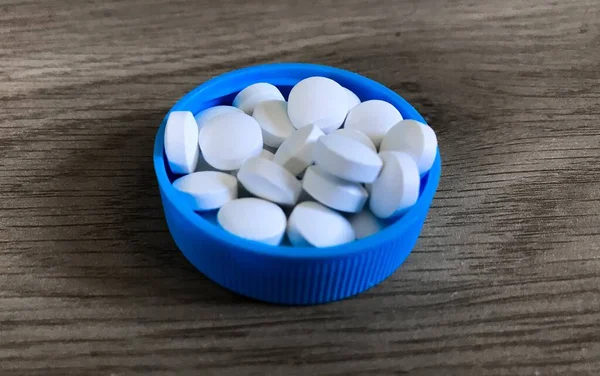 Detailní Záběr Bílých Pilulek Modré Plastové Čepici Dřevěném Pozadí — Stock fotografie