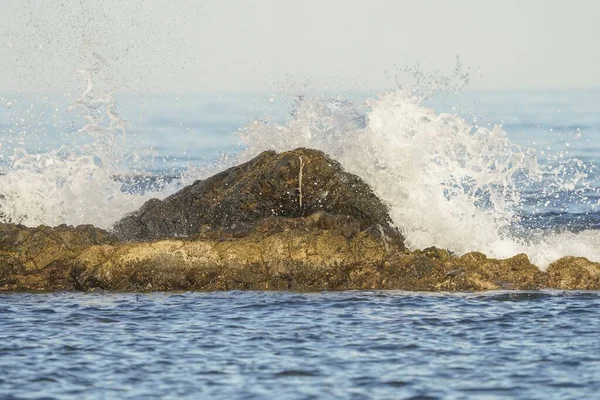 强大的海浪冲击着海里的一块大石头 — 图库照片