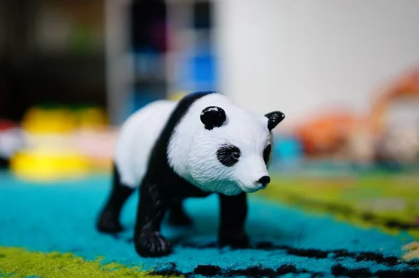 Close Panda Brinquedo Tapete Azul Sob Luzes Com Fundo Embaçado — Fotografia de Stock