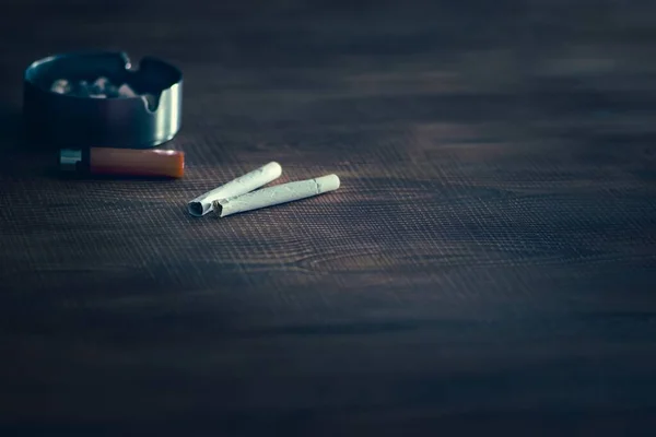 Ένα Κοντινό Πλάνο Των Τσιγάρων Στο Τραπέζι Έναν Αναπτήρα Και — Φωτογραφία Αρχείου