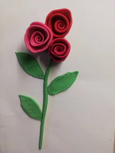 白い表面に粘土で作られた赤いバラのクローズアップショット — ストック写真