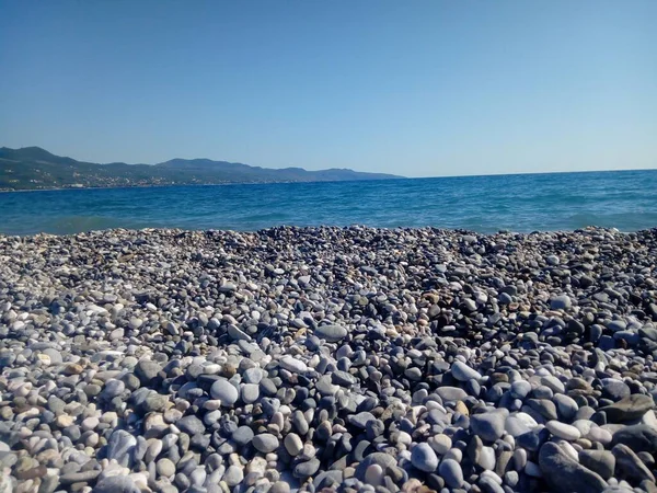 Uma Vista Mar Azul Cheio Pedras Com Uma Montanha Alta — Fotografia de Stock