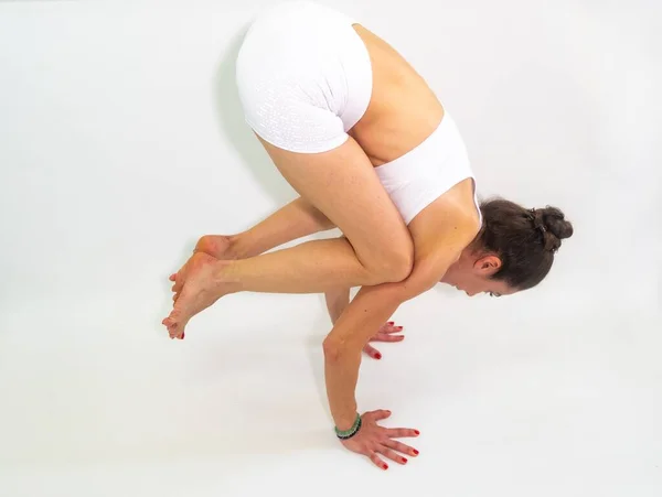 Jonge Vrouw Een Witte Outfit Doet Complexe Yoga Oefeningen — Stockfoto