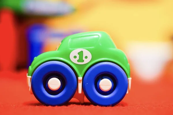 Tiro Close Pequeno Carro Brinquedo Uma Superfície Vermelha Com Fundo — Fotografia de Stock