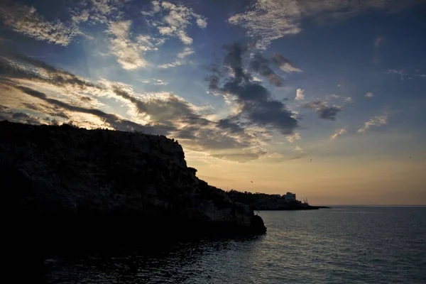 Silhouette Cliffs Surrounded Sea Cloudy Sky Sunset — Stock Photo, Image