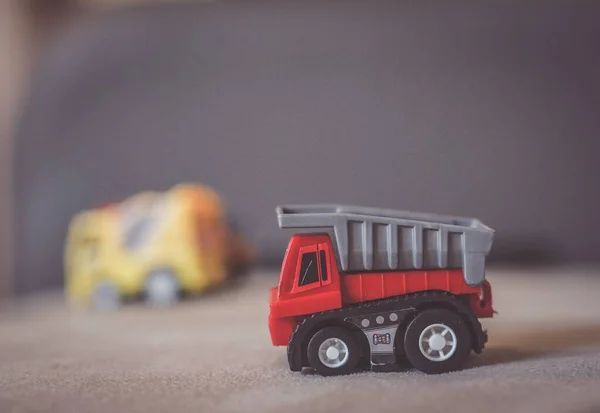 Zbliżenie Ujęcia Plastikowej Czerwonej Ciężarówki Budowlanej Szarej Powierzchni — Zdjęcie stockowe