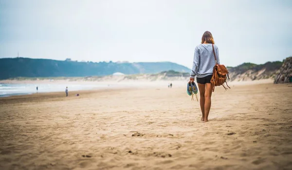 Young Female Brown Backpack Holding Her Shoes Walking Beach Sunlight — Stock Photo, Image