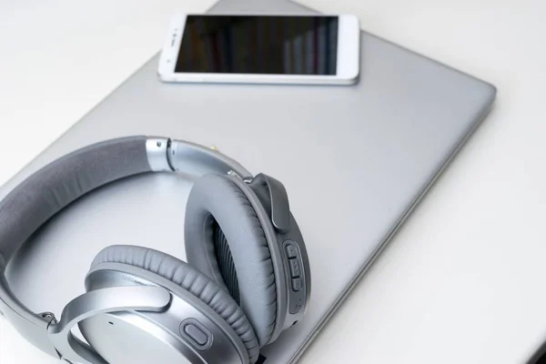 Ein Modernes Smartphone Und Graue Kopfhörer Auf Einem Grauen Laptop — Stockfoto