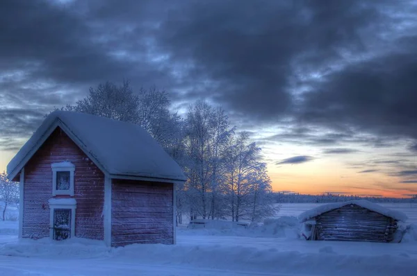 Mały Drewniany Domek Polu Pokryty Śniegiem Podczas Zachodu Słońca — Zdjęcie stockowe