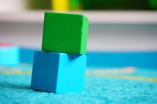 青いラグに隔離されたカラフルな木製のおもちゃのブロックのクローズアップショット — ストック写真