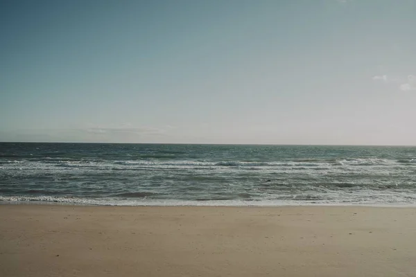 暖かくて晴れた日に撮影された砂浜で美しい海の息をのむような景色 — ストック写真
