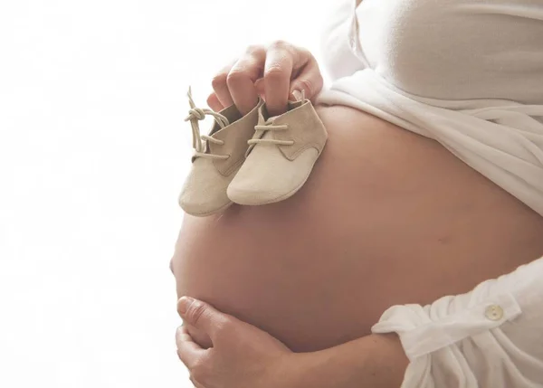 Egy Közelkép Egy Terhes Nőről Aki Cipőt Tart Egy Gyereknek — Stock Fotó