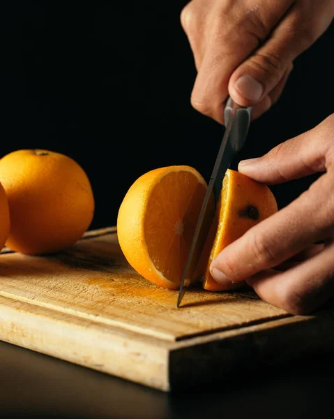 灯の下の板にオレンジを切る者の縦射 — ストック写真