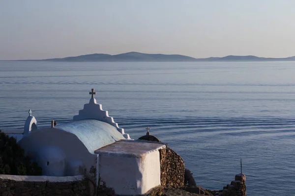 背景の丘と穏やかな海の海岸にある古い白い礼拝堂 — ストック写真