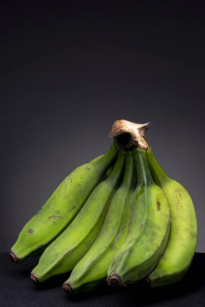 Primer Plano Vertical Montón Plátanos Verdes Inmaduros Con Fondo Negro — Foto de Stock