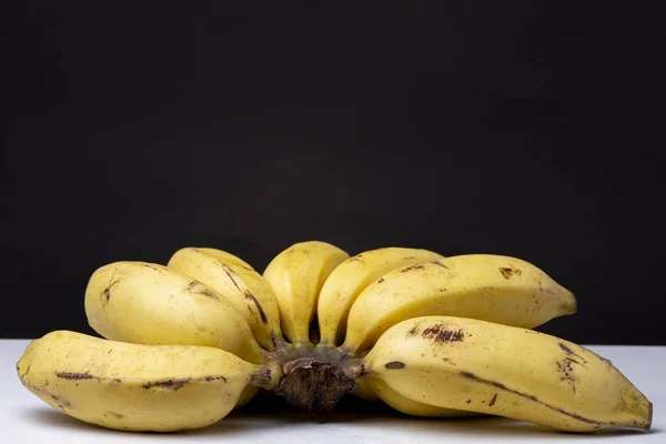 Clsoeup Shot Bunch Ripe Yellow Bananas White Surface Black Background — Stock Photo, Image