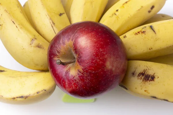 熟した黄色のバナナの束に赤い鮮やかなリンゴのクローズアップショット — ストック写真