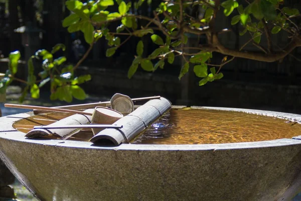 木の下にスクープ付きの水の大鉢のクローズアップショット ストック画像