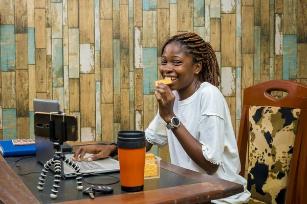 Uma Jovem Mulher Africana Feliz Gravando Enquanto Come Biscoito Fundo — Fotografia de Stock