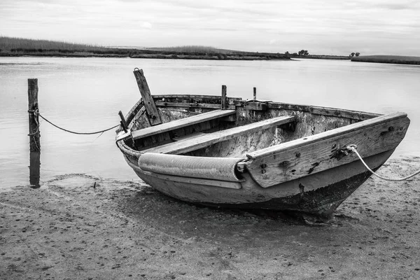 湖滨一艘旧木船的灰白色镜头 — 图库照片
