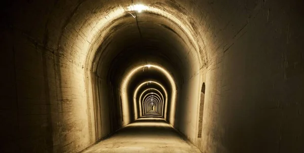 Een Lange Tunnel Met Bruine Muren Verlicht Met Lampen — Stockfoto