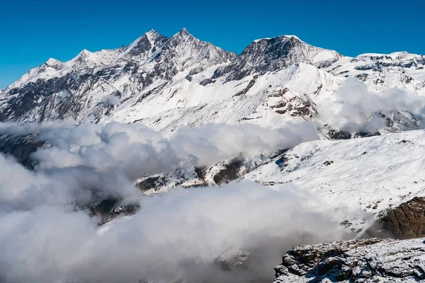 スイスの澄んだ青空の下で雪に覆われた高い岩山の美しい景色 — ストック写真