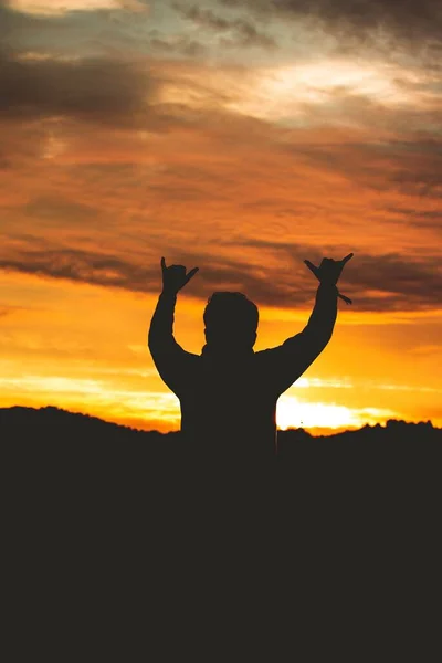 Sylwetka Człowieka Robiącego Znak Palcami Kolorowym Niebie Zachodu Słońca — Zdjęcie stockowe
