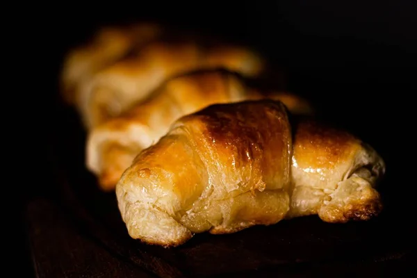 Eine Nahaufnahme Von Köstlichen Croissants Einer Reihe Unter Dem Licht — Stockfoto