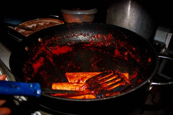 The process of cooking Mexican traditional dish enchiladas with cheese and potatoes