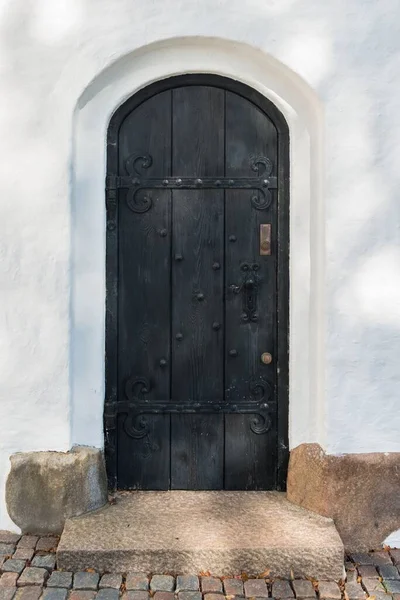 Tiro Vertical Uma Porta Madeira Antiga Preta Sob Luz — Fotografia de Stock