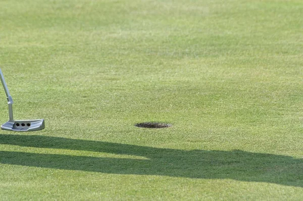 Çukurun Önünde Bir Golf Sopası Çimlerin Üzerinde Bir Insanın Gölgesi — Stok fotoğraf