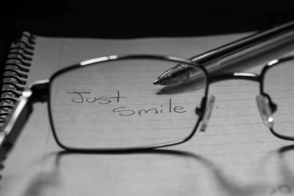 Greyscale Closeup Shot Eyeglasses Notebook Text Just Smile Written — Stock Photo, Image