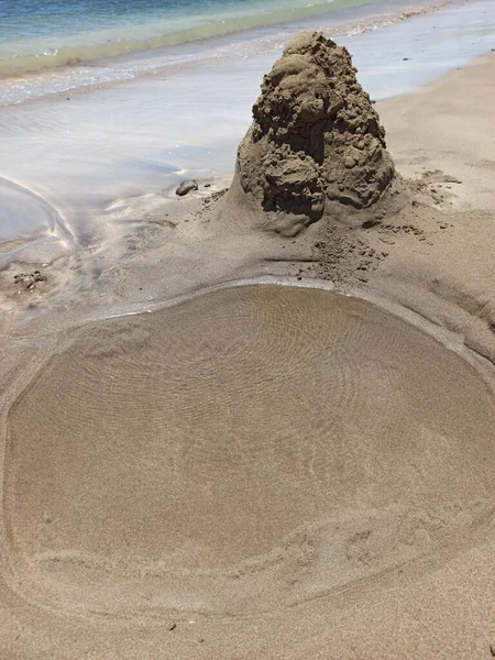 Close Buraco Escavado Areia Cheia Água Uma Pilha Areia Lado — Fotografia de Stock