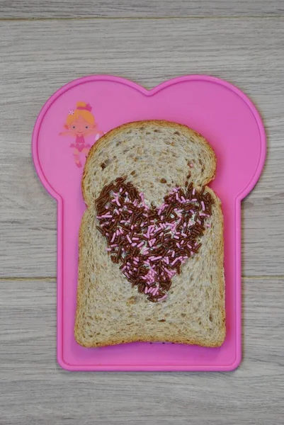 Eine Vertikale Aufnahme Eines Toastes Mit Schokoladenstreuern Einem Rosa Plastikteller — Stockfoto