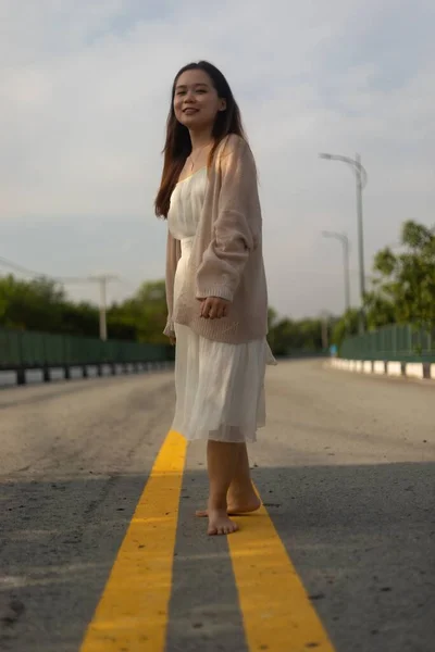 Beyaz Elbiseli Sokakta Poz Veren Asyalı Bir Kadının Dikey Fotoğrafı — Stok fotoğraf