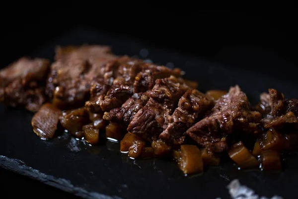 Mięso Gotowane Karmelizowaną Cebulą Typowe Hiszpańskie Jedzenie Czarnym Tle — Zdjęcie stockowe