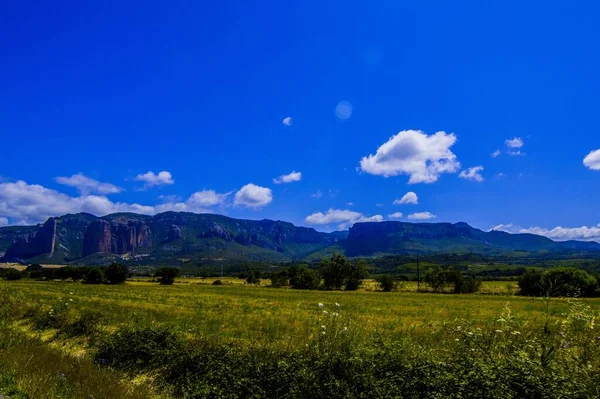 Dağlı Bir Çayır Manzarası Arkasında Bulutlu Mavi Bir Gökyüzü — Stok fotoğraf