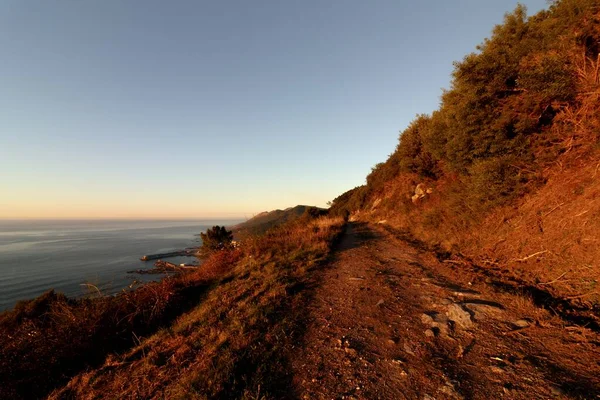 Длинный Скалистый Путь Окруженный Холмами Морем Сверкающим Голубым Небом — стоковое фото